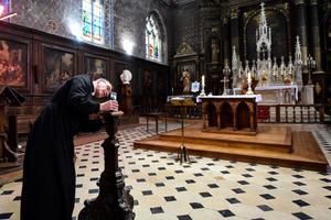 Father Olivier Monnier installs his mobile phone on a wooden candlestick as he prepares to broadcast the 11 o'clock Mass with a video chat smart phone application on April 3, 2020, at Saint-Jacques church in Illiers-Combray, France.