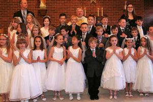 Father George DeVille and first communicants at Holy Rosary parish in Muse, Pennsylvania.