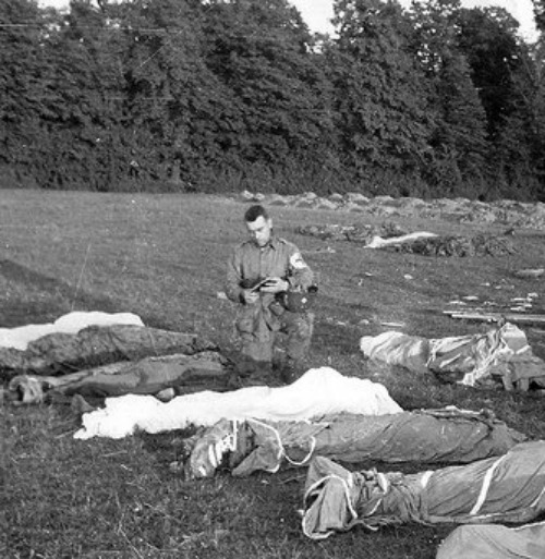 Father Francis Sampson, who was known as the 'Parachute Padre,' gives last rites to paratroopers killed in action during the D-Day invasion of Normandy.