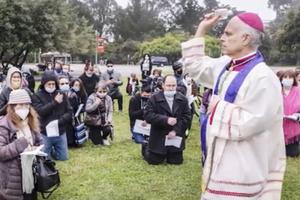 Archbishop Salvatore Cordileone sprinkles holy water on Catholics gathered in Golden Gate Park at the site where the statue of St. Junípero Serra once stood. 