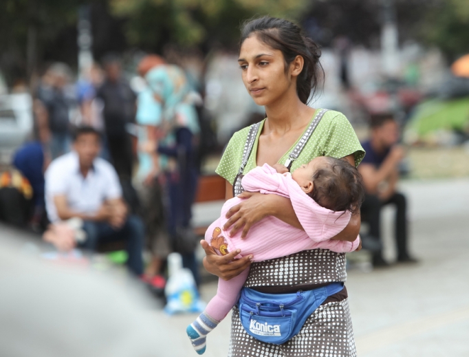 A young woman waits with her child by the train station in Belgrade, Serbia. 