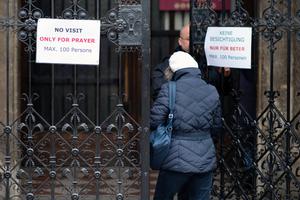 A woman enters St. Stephen's Cathedral in Vienna, Austria, on Wednesday. To help combat the spread of the coronavirus the Austrian government has forbidden all indoor events with more than 100 people attending.