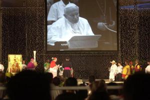 Hundreds of people attending an international Catholic conference on the role of the family listen to a broadcast of Pope John Paul II at a public park in the Philippine capital, Manila, Jan. 25, 2003, during the prayer vigil of the fourth World Meeting of Families. The meeting was called by Pope John Paul II to reaffirm the Christian family’s role in society.