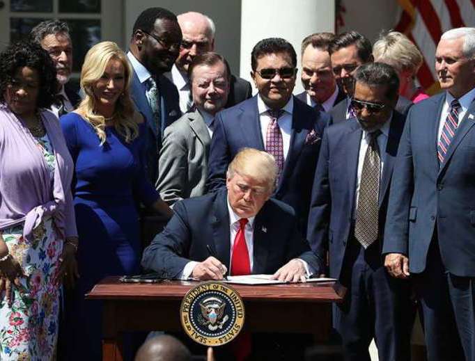 President Donald Trump signs a proclamation at the National Day of Prayer event held in the Rose Garden on May 3, 2018.
