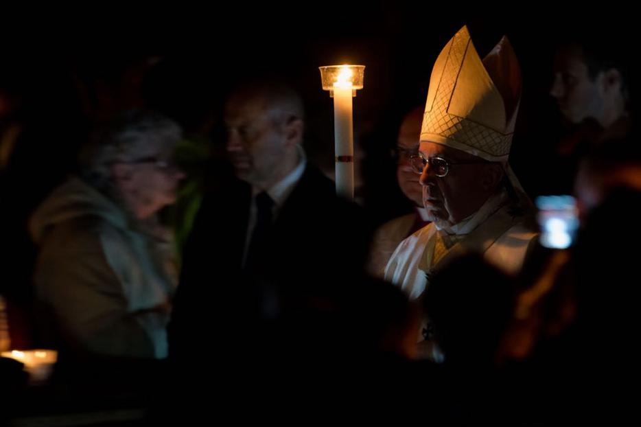 Pope Francis holds the Paschal candle as he leads the procession into St. Peter's basilica. 