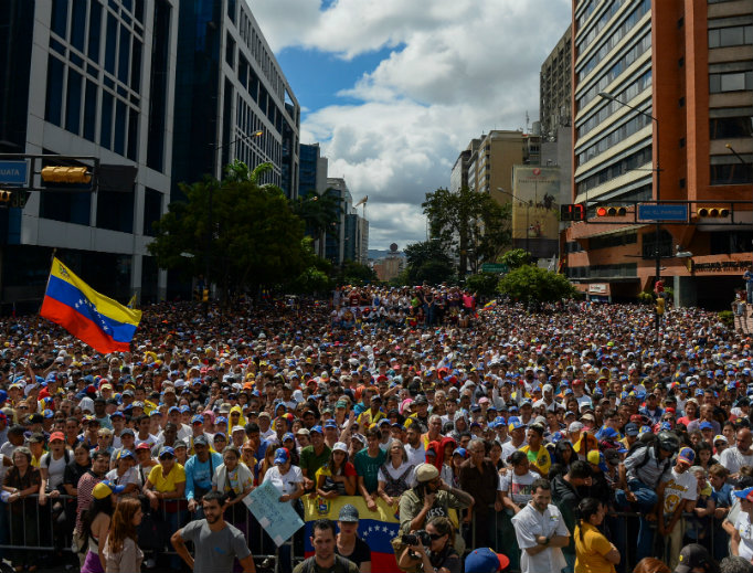 People listen to Venezuela's National Assembly head Juan Guaido (out of frame) during an opposition rally against Nicolas Maduro in Caracas on Jan. 23.  