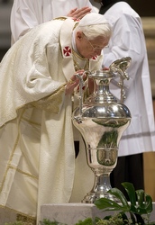 Benedict breathes into chrism oil at today's Holy Thursday chrism Mass.