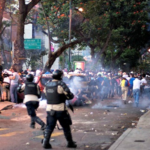Protesters run from riot police on Feb. 15 in Altamira, Caracas, Venezuela.