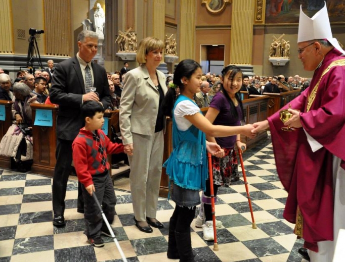 Archbishop Charles Chaput greets gift-bearers at a Mass for persons with disabilities and the deaf community.