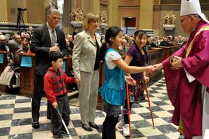 Archbishop Charles Chaput greets gift-bearers at a Mass for persons with disabilities and the deaf community.