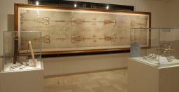 A life-size reproduction of the Shroud of Turin is seen in a permanent exhibit at Regina Apostolorum University in Rome Jan. 21. At left are examples of Roman whips for scourging; at right is a crown of thorns. Although the Shroud of Turin has been studied from virtually every scientific angle, no one has been able to fully explain how the image was transferred to the linen cloth.