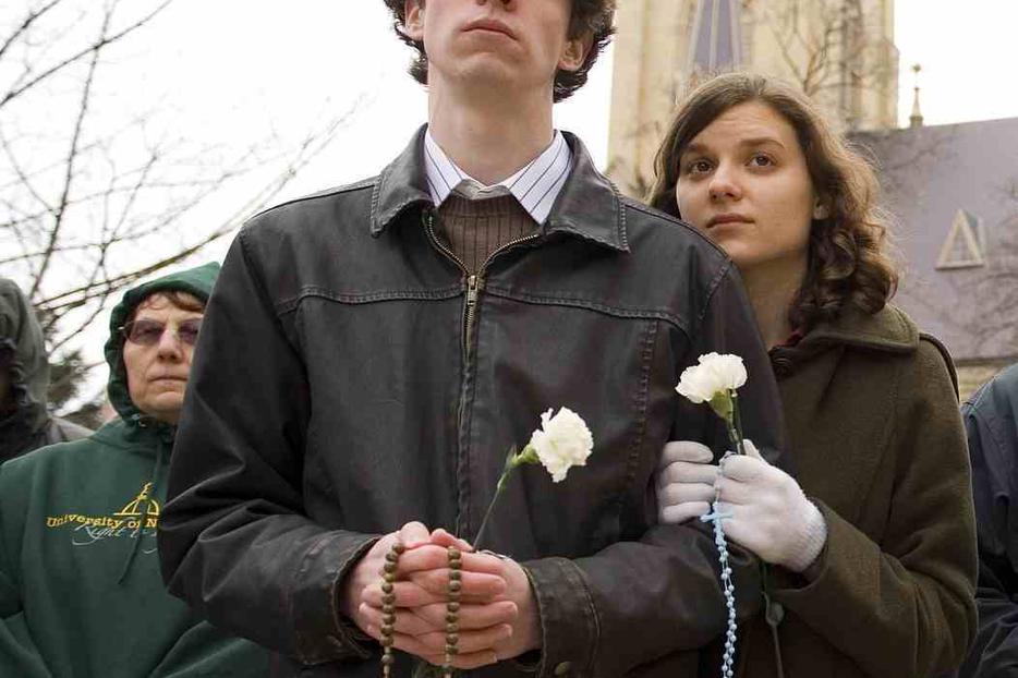 People hold rosaries during a rally protesting Notre Dame's honoring of President Obama.