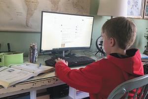 A sixth-grade student from Our Lady of Mount Carmel School in Carmel, Indiana, attends class online during the coronavirus shutdown. 