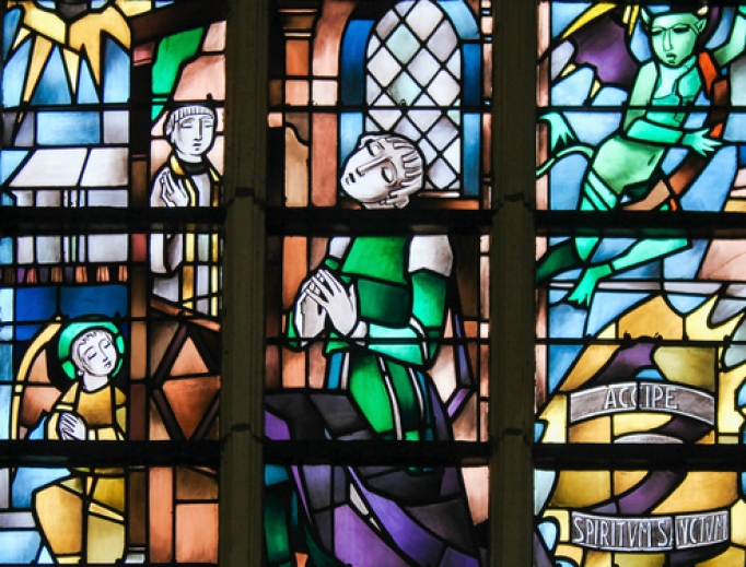 Stained glass image of penitent on a Catholic church in Belgium.