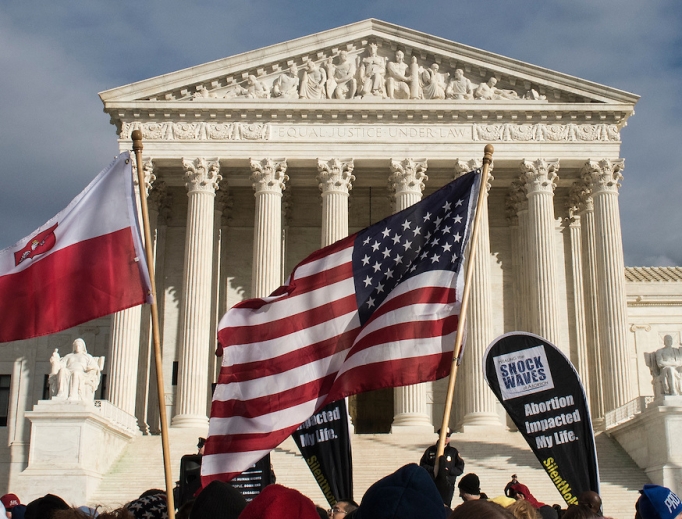 March for Life participants carry signs in front of the Supreme Court building in Washington.