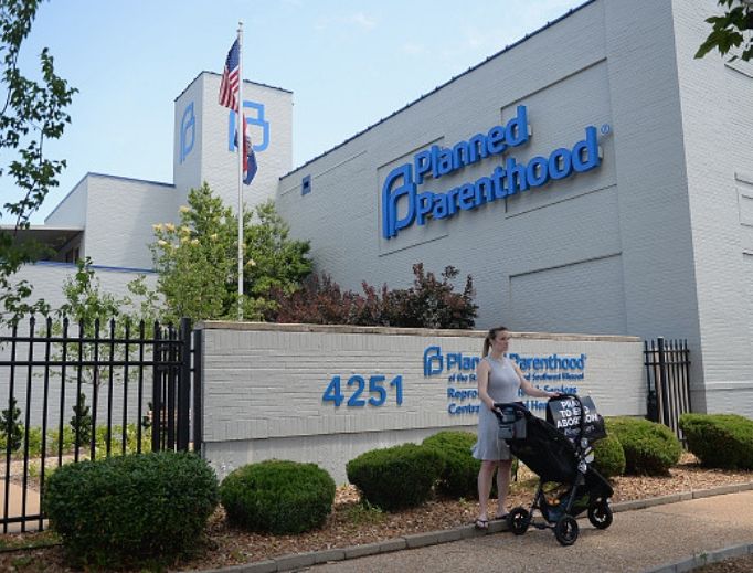 A woman stands with her child in a stroller during a pro-life rally outside Planned Parenthood in St. Louis, June 4, 2019. 