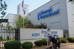 A woman stands with her child in a stroller during a pro-life rally outside Planned Parenthood in St. Louis, June 4, 2019. 