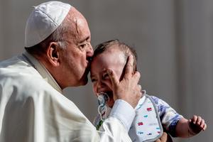 Pope Francis kisses an infant on the forehead during his weekly General Audience, 2019. 