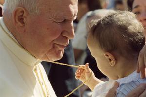 Pope St. John Paul II greets a child Sept. 16, 1998.
