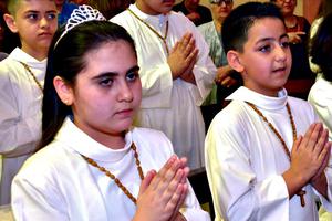 Iraqi Christian children, uprooted from their homes in the Nineveh Plain by the Islamic State in the summer of 2014, make their First Solemn Communion with Syriac Catholic Patriarch Ignace Joseph III Younan at the Cathedral of Our Lady of the Annunciation in Beirut, Lebanon.