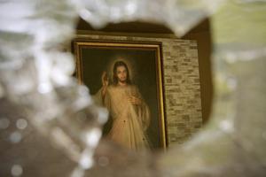 Above, A painting of Jesus Christ pierced with bullet holes is seen July 24 through an entrance point of a bullet hole in a window of the Jesus of Divine Mercy Church in Managua, Nicaragua. For nearly 15 hours overnight on July 13-14, heavily armed pro-government groups fired on the church while about 100 student protesters who had been forced out of the nearby university lay under pews in the main sanctuary. 