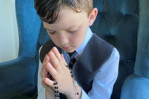 Fletcher Abner with his first Communion rosary. The rosary he is holding was made by his grandmother, Shirley Jones. She has made more than 20 for her grandchildren on their first Communion.
