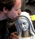 A fireman kisses a statue of Mary recovered from a church in Paganica, Italy.