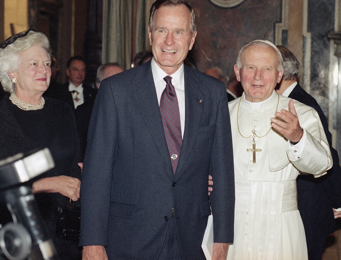 Pope John Paul II invites President George Bush, accompanied by his wife, Barbara, to meet members of the clergy gathered in the Vatican's Clementine Hall Nov. 8, 1991.