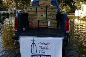 Above, Catholic Charities provided some disaster-relief services to a flooded neighborhood in Socastee, S.C. Residents were unable to leave their homes. Below, Lisa Muir and her daughter, Audrey, sort supplies donated for flood victims at St. Joseph Church in Columbia.

