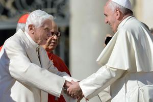 Pope Emeritus Benedict XVI speaks with Pope Francis during a Mass for elderly people in St. Peter's Square on Sept. 28, 2014.
