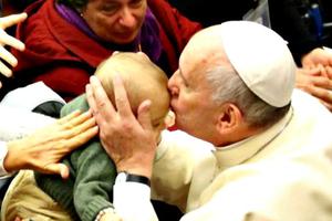 Pope Francis kisses a baby at a Pontifical Council for Health Care conference on autism Nov. 22.