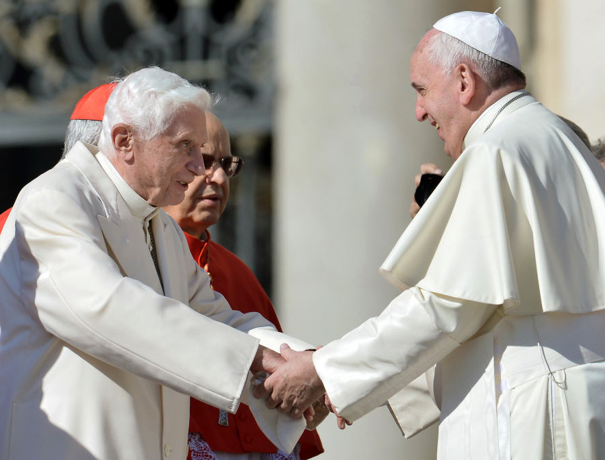 Pope Emeritus Benedict XVI speaks with Pope Francis during a Mass for elderly people in St. Peter's Square on Sept. 28, 2014.
