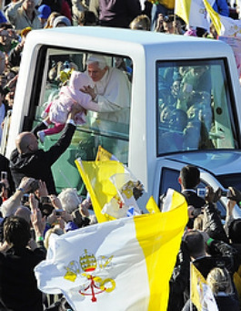 Pope Benedict XVI kisses infant Maria Tyszczak of Poland as he arrives to celebrate Mass at Bellahouston Park in Glasgow, Scotland, on the first day of his four-day visit to Great Britain.