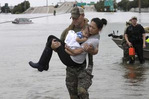 Houston Police SWAT officer Daryl Hudeck carries Catherine Pham and her 13-month-old son, Aiden, after rescuing them from their home surrounded by floodwaters from Tropical Storm Harvey Aug. 27 in Houston. The remnants of Hurricane Harvey sent devastating floods pouring into Houston Sunday as rising water chased thousands of people to rooftops or higher ground. 