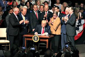 President Donald Trump signs policy changes he is making toward Cuba at the Manuel Artime Theater in the Little Havana neighborhood on June 16 in Miami. 