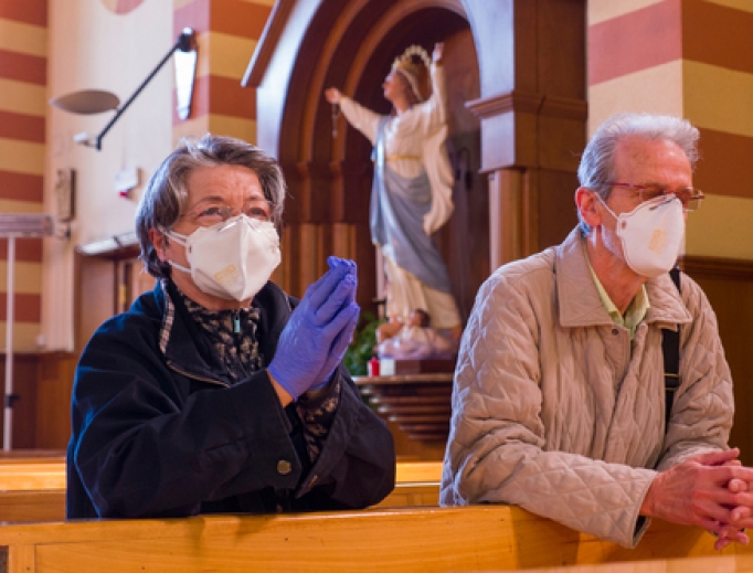 A couple prays in the church of San Giuseppe dei Falegnami in Rome during the coronavirus lockdown taking advantage of the few hours of opening of the church, April 11, 2020. 