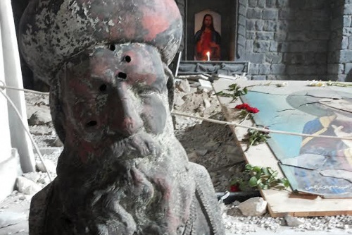 A bullet-riddled bust of St. Ephrem in the remains of St. Mary's Syrian Orthodox parish in Homs. 