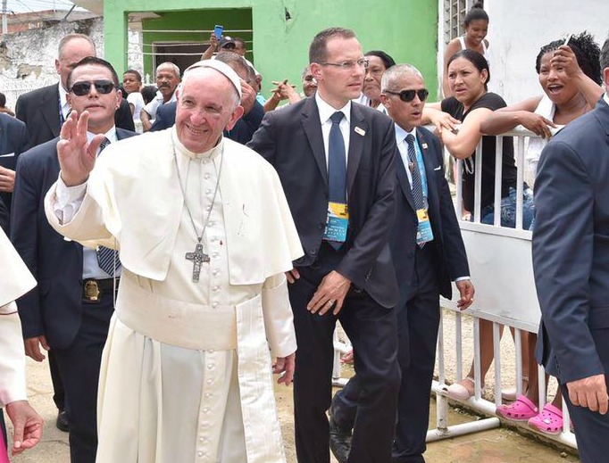 With a bruise and a scrape visible on the left side of his face, Pope Francis smiles and waves as he walks following a minor slip on the Popemobile. 