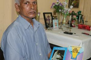 Mathew Uzhunnalil, the oldest brother of kidnapped Salesian Father Thomas Uzhunnalil, sits with a prayer book on March 28 in the family’s ancestral home in Ramapuram, India.
