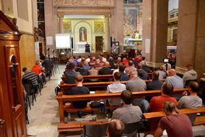 Above, men listen to Capuchin Father Raniero Cantalamessa speak in Rome. Below, Father Cantalamessa talks, and Mass is celebrated.

