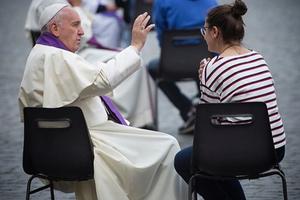 Pope Francis hears confession of a teen on April 23 in St. Peter's Square.