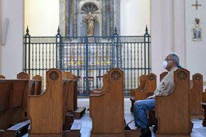 A man uses a face mask as a precautionary measure in the face of the global COVID-19 coronavirus pandemic, as he attends Mass in Bogotá on March 12, 2020.
