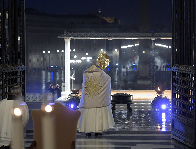 Holding the Blessed Sacrament in a monstrance, Pope Francis stands before an empty St. Peter’s Square — and a large TV, radio and internet audience worldwide — as he blesses “the City (of Rome) and the World” (Urbi et Orbi) Friday.