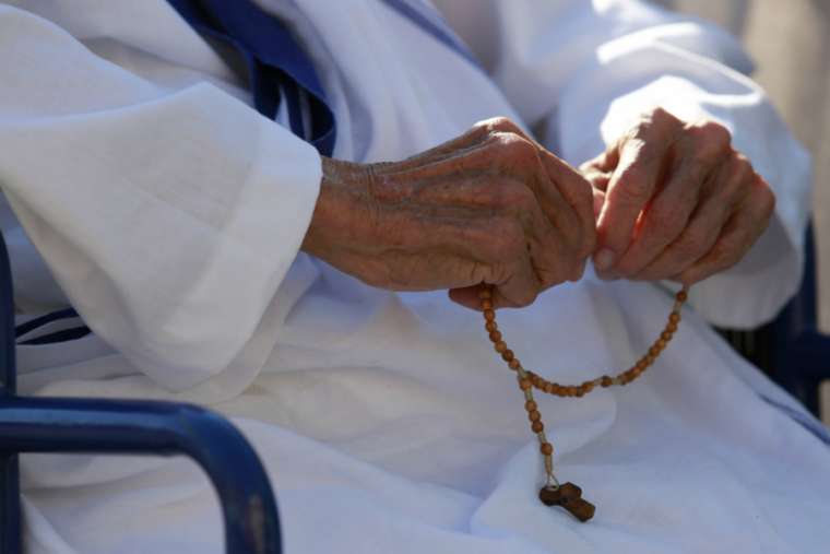 Missionary of Charity sister prays the Rosary. 

