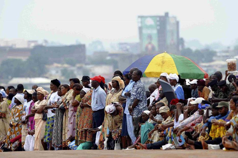 People stand outside Amadou Ahidjo Stadium in Yaounde, Cameroon, as Benedict celebrates Mass there March 19.