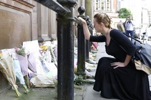 A woman prays May 23 as she views floral tributes left outside St Ann's Church, Manchester, following the Manchester Arena bomb attack. The attack killed 22 people, including children, and injured dozens more in the worst terrorist incident to hit Britain since the July 7, 2005, atrocities. 