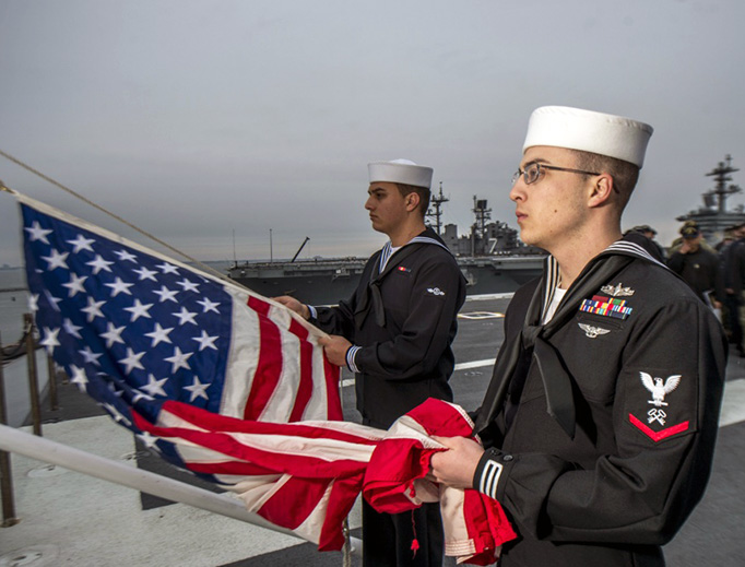 Sailors conduct morning colors on the flight deck of the aircraft carrier USS George H.W. Bush (CVN 77). The flag was flown at half-mast to honor the 41st President, George H.W. Bush, the ship’s namesake, who passed away Nov 30.