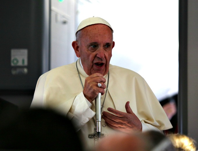 Pope Francis speaks to journalists during a press conference on the papal flight to Rome on July 31.