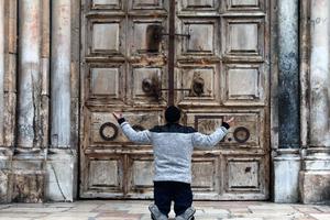 A man kneels in prayer in front of the closed doors of the Church of the Holy Sepulcher in Jerusalem April 9, during the COVID-19 pandemic lockdown. 