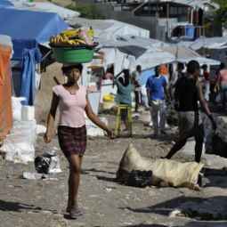 A woman carrying goods walks through the largest tent city of Haitian earthquake survivors, located on a former nine-hole golf course, in Port-au-Prince, Haiti, Oct. 22. The Petionville Club was hosting more than 44,000 people.